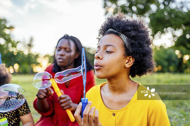 在户外吹泡泡的女孩图片素材