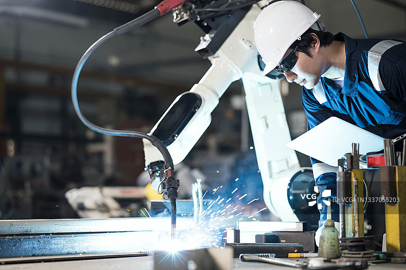 生产过程中的焊接效率分析：机械工程师使用笔记本电脑检查焊接过程的精度测试、数据分析和建模技术，并进行焊接质量评估。图片素材