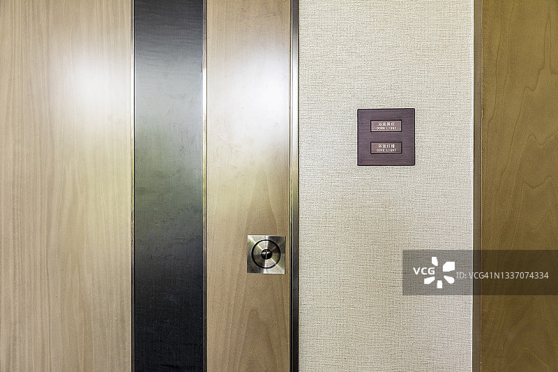 现代门附近白色墙壁上的电灯开关图片素材