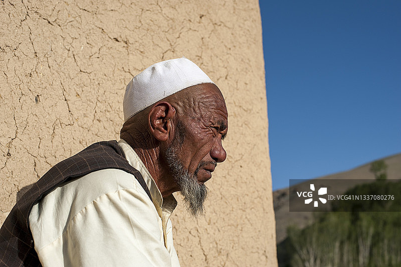 阿富汗巴米扬省：清晨，农民在自家房屋外查看田地图片素材