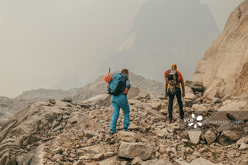 两名登山者在阿尔卑斯山的大块巨石区中行走图片素材
