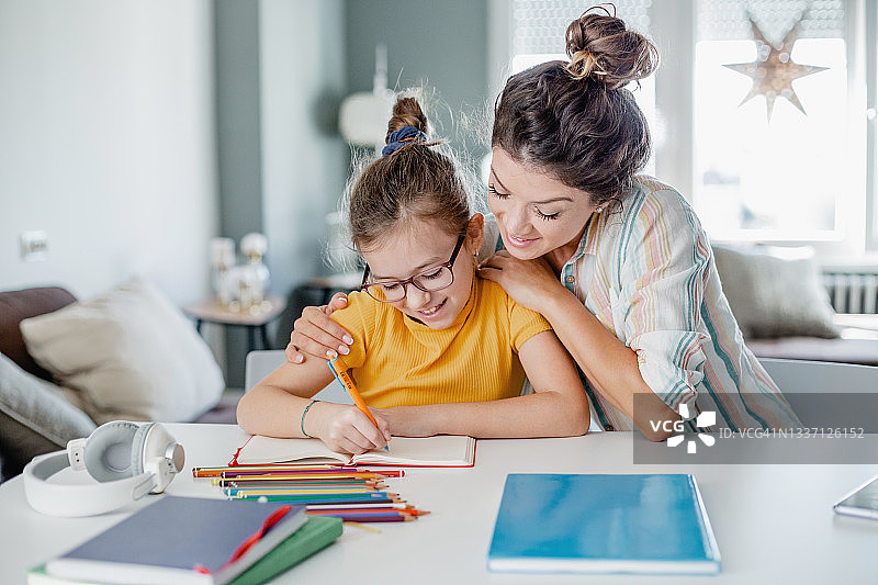 母亲帮助女儿学习功课图片素材
