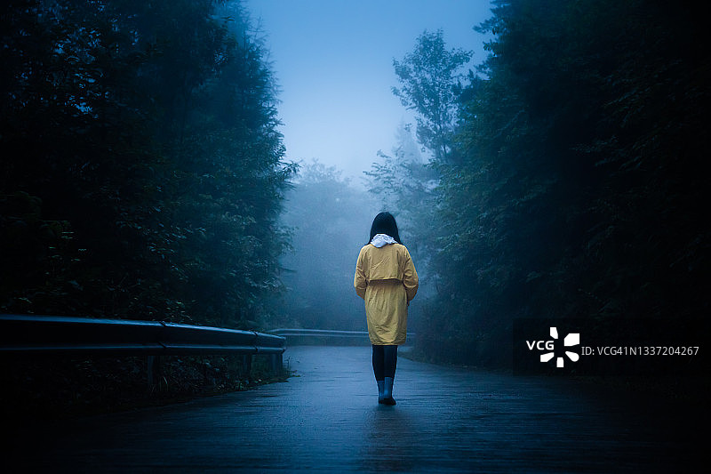 孤独的女人走在雾路上图片素材
