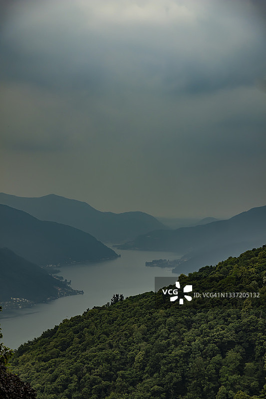 阴天风暴云下的卢加诺湖和山脉全景图片素材