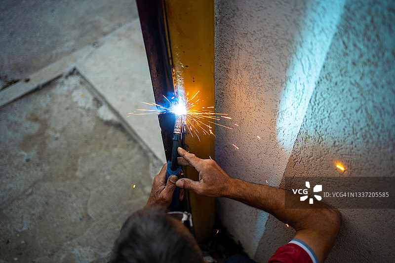 男人焊接旧大门图片素材