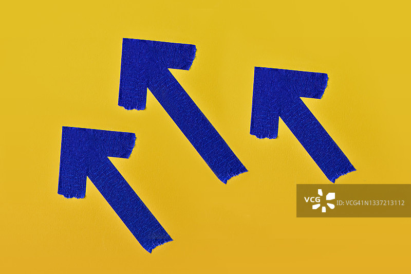 黄色背景上胶带形成的箭头静物图片素材