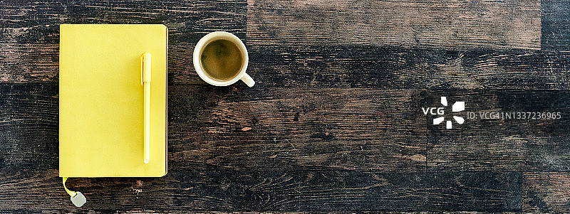 木桌上的黄色笔记本和黄色笔图片素材