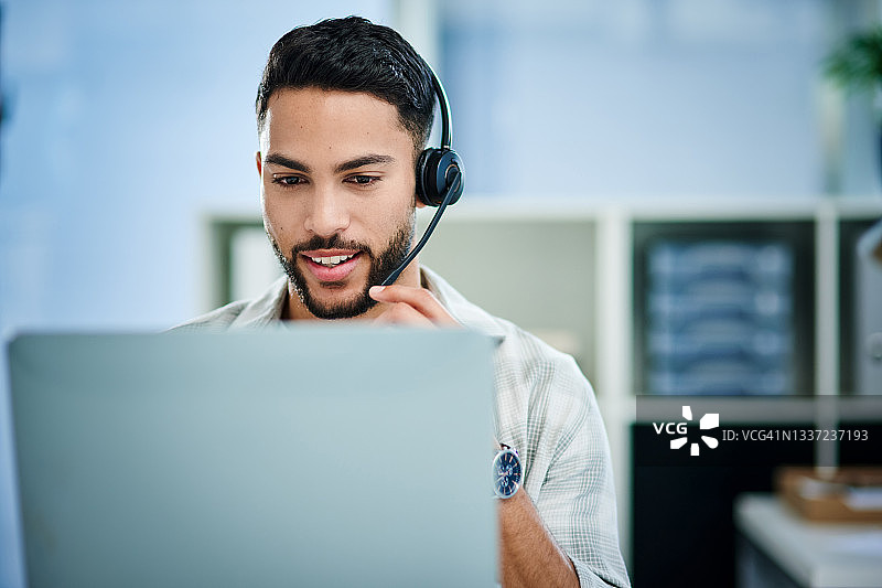 年轻男子在呼叫中心工作的照片图片素材