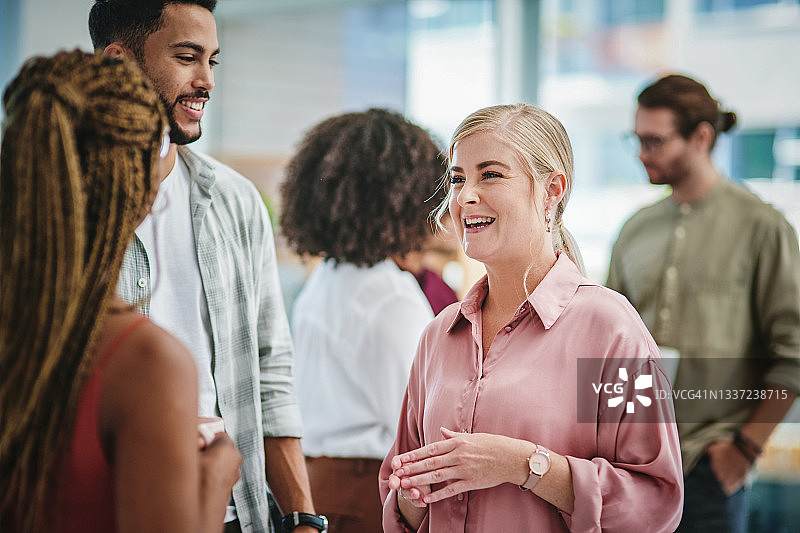 年长的女CEO与团队成员交谈图片素材
