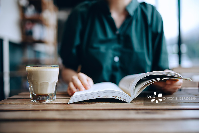 年轻女人在咖啡馆享受咖啡和阅读的休闲时光图片素材