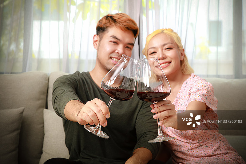 情侣在家浪漫晚餐，举杯共饮红酒图片素材