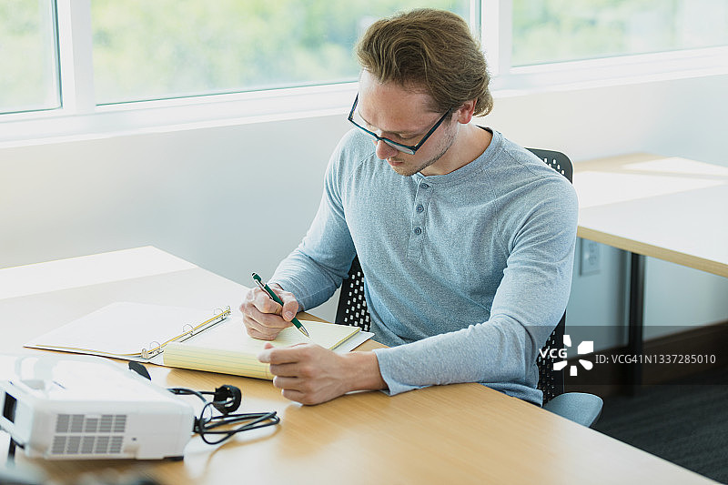中年男教师为课堂准备讲义图片素材