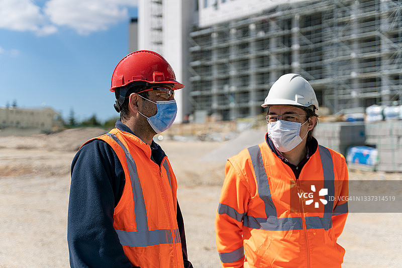 戴防护口罩的两名工程师正在检查图片素材