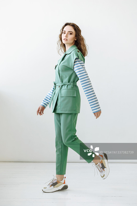 身穿时尚绿色套装的女模特摆姿势图片素材