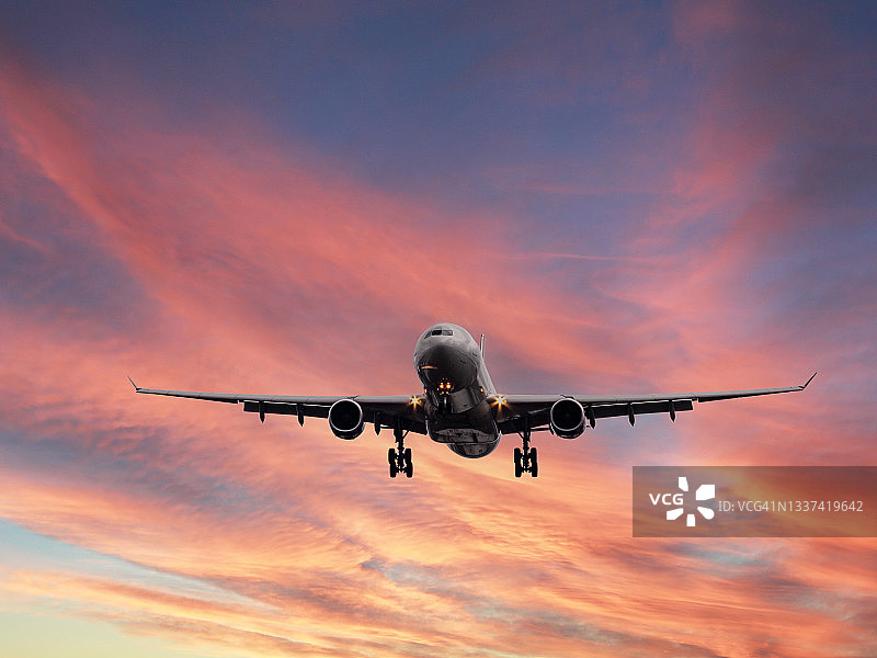 飞机在日落背景下着陆的特写跟踪镜头图片素材