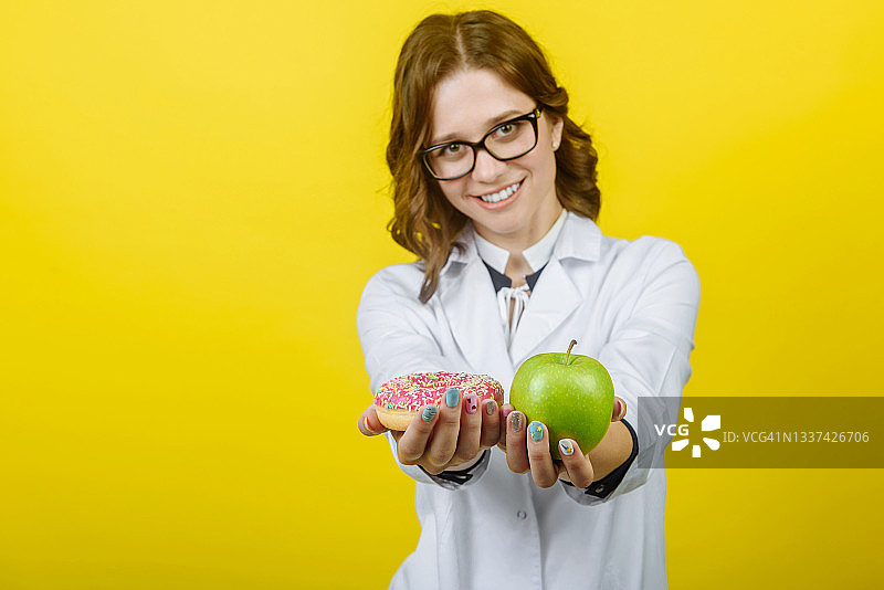 营养师拿着甜甜圈和苹果图片素材