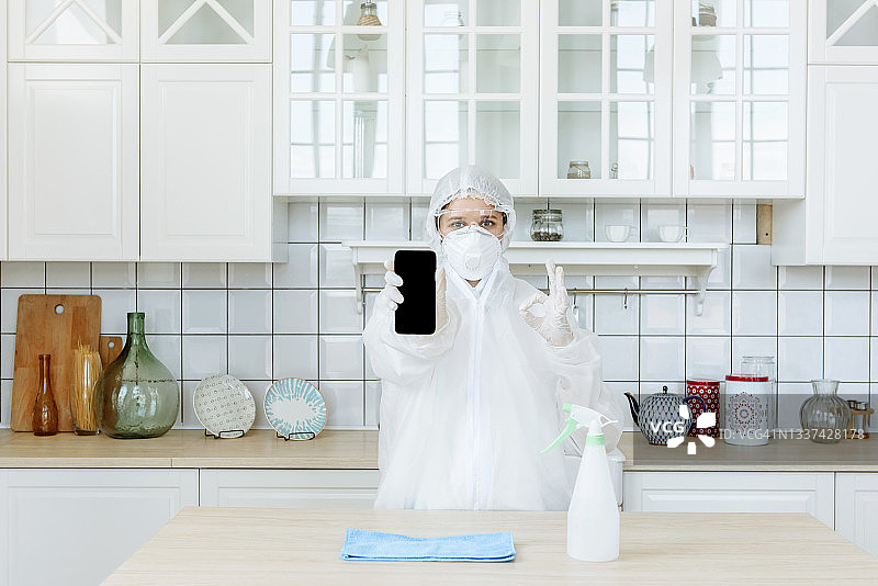 站在厨房里并做出积极姿势的害虫或病毒防治人员，关于新冠病毒消毒的概念图片素材