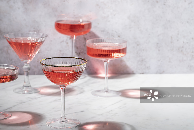 阳光明媚的白色大理石上的粉色玫瑰鸡尾酒图片素材