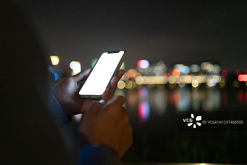 男人夜晚使用智能手机，手部特写图片素材