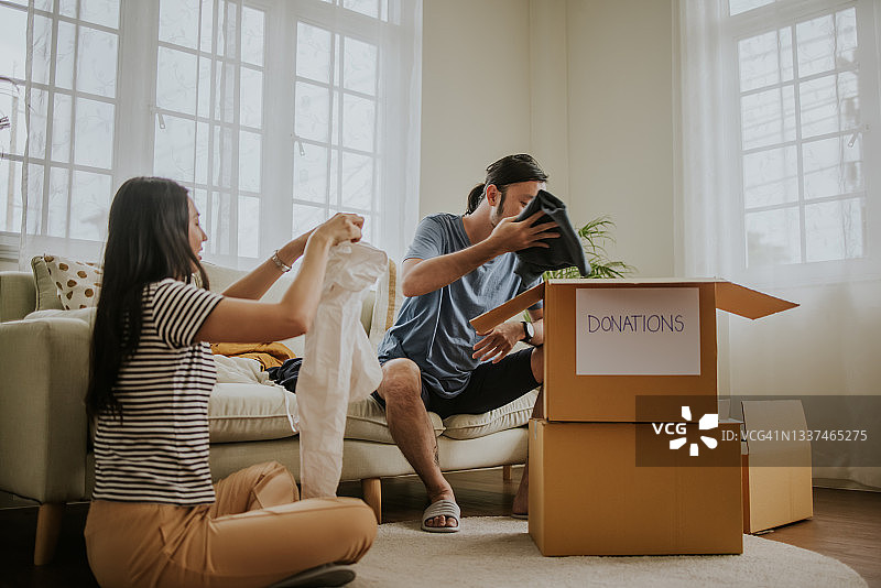 年轻夫妇整理衣物准备捐赠图片素材