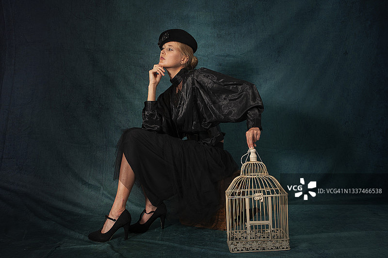 拿着鸟笼的复古年轻女人图片素材