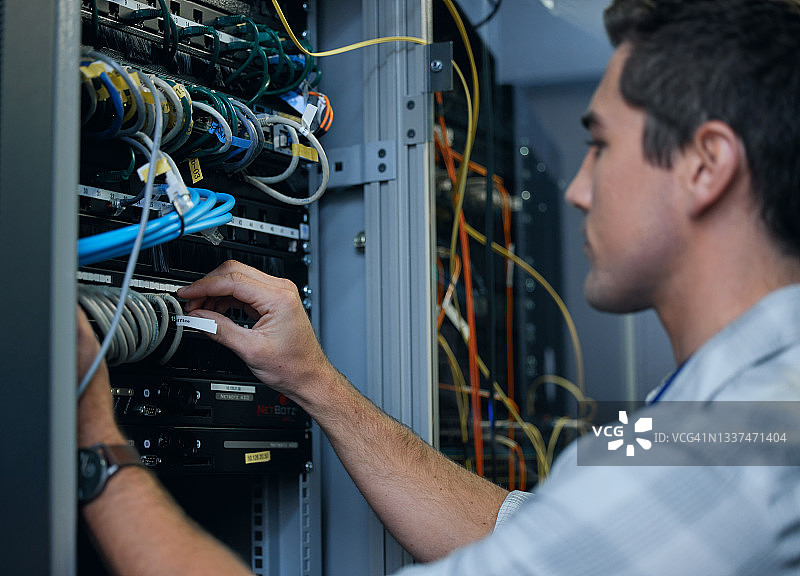 年轻帅气的程序员在服务器机房工作特写图片素材