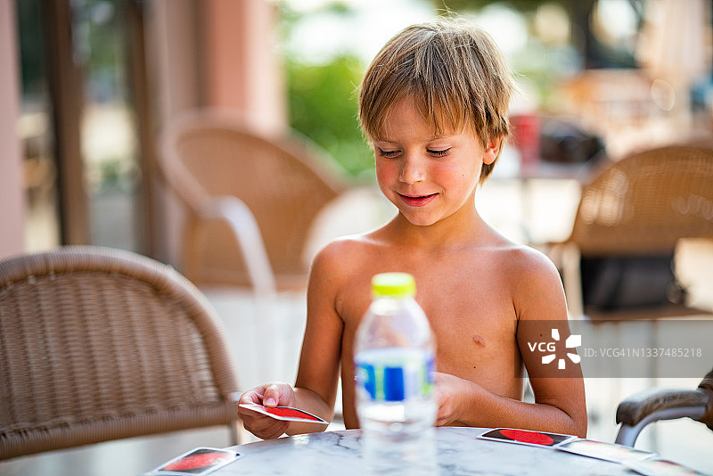 男孩在夏日玩纸牌图片素材