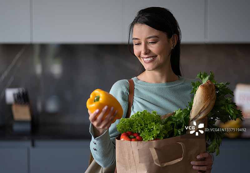 在家打开一袋杂货的快乐女人图片素材