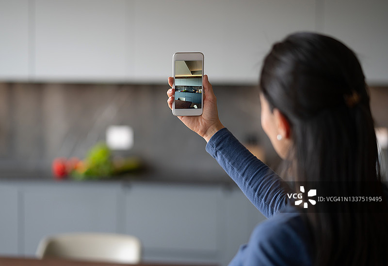 女人用手机观看虚拟售楼图片素材