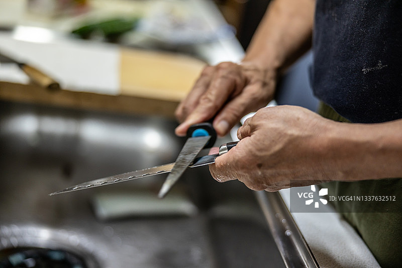 男人在厨房磨刀图片素材