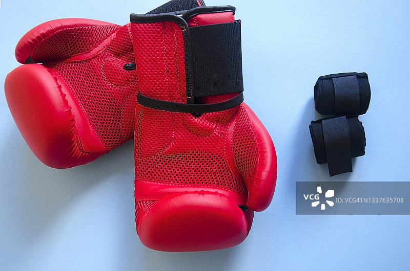 蓝色背景上的红色拳击手套和黑色绷带图片素材