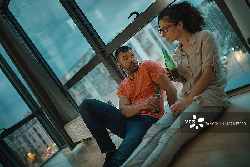 年轻情侣在家喝啤酒图片素材