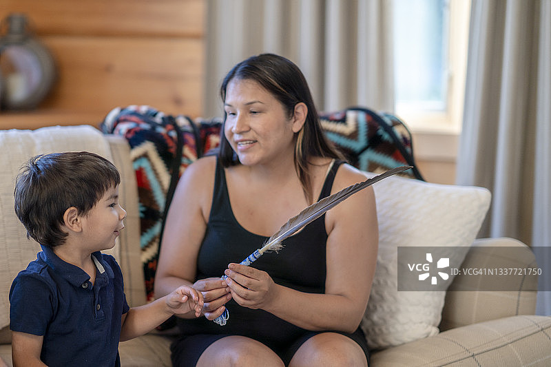 土著母亲与年幼的儿子分享文化故事图片素材