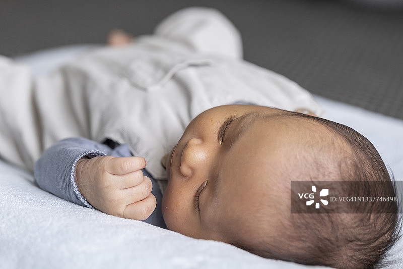 亚裔和白人混血的一周大男婴睡着特写照片图片素材