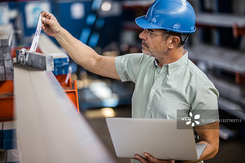 在工业建筑中使用笔记本电脑的质量控制检验员图片素材