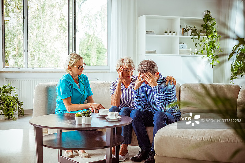 护士与担忧的老年夫妇交谈图片素材