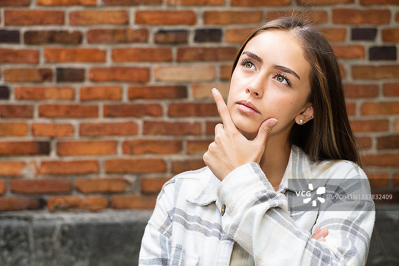 沉思，思考和抬头的年轻拉丁裔女人图片素材