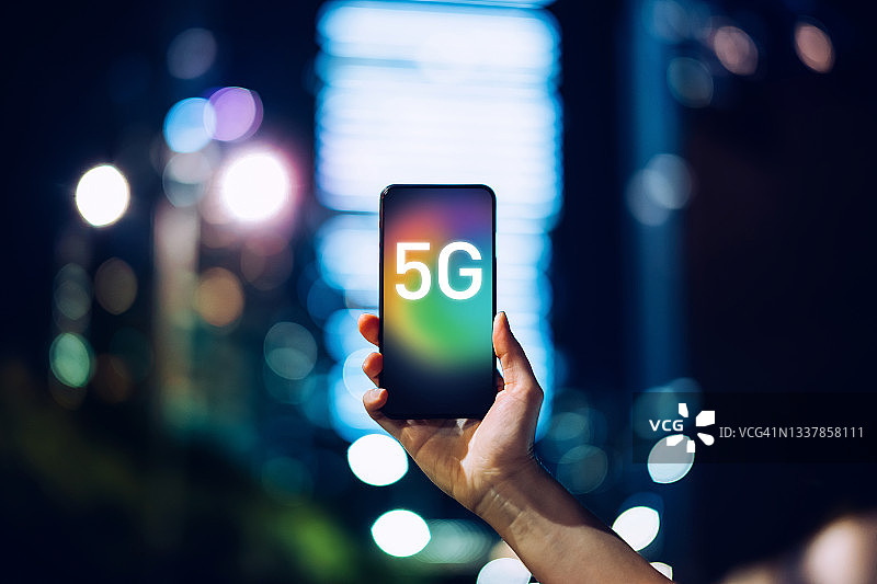 女人在城市金融区使用智能手机，5G通信技术概念图片素材