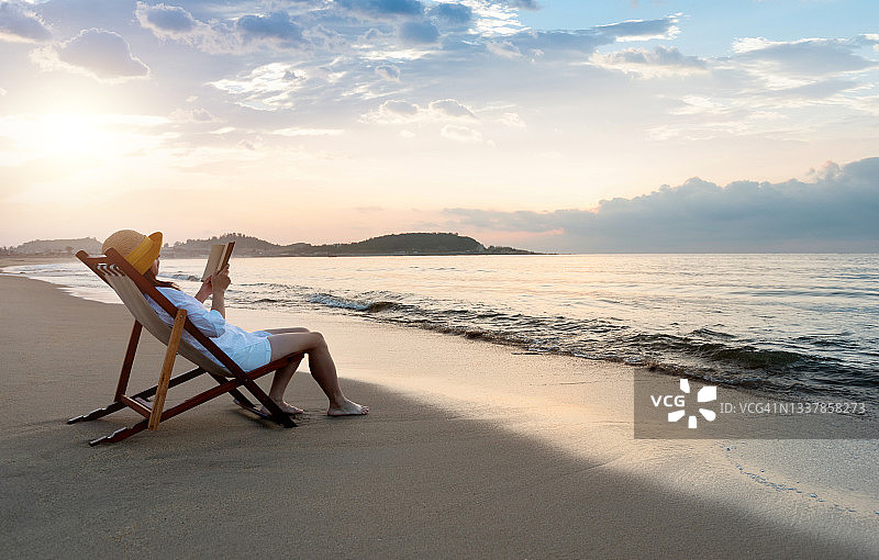 在海边阅读书籍的女人图片素材