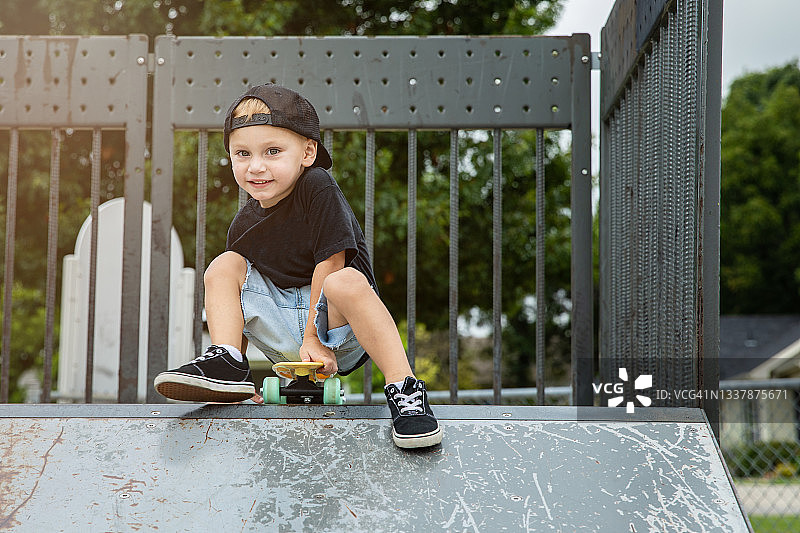 小男孩在城市滑板公园玩滑板图片素材