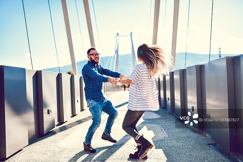 在桥上微笑跳舞的情侣图片素材