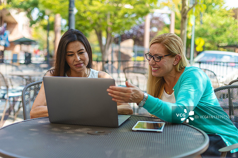 X一代成熟女性在户外桌旁使用科技设备系列照片图片素材