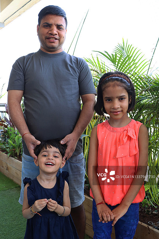 印度男人与小女儿在公寓阳台的家庭合影图片素材