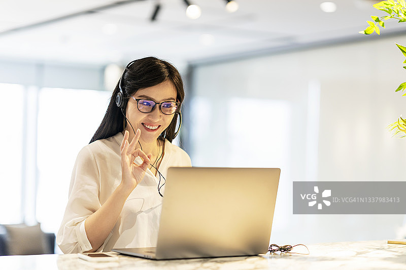 自信的亚洲女商人与她的商业伙伴进行视频会议图片素材