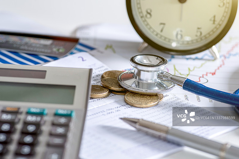 带有纸币和听诊器的计算器。健康保险计划概念。图片素材