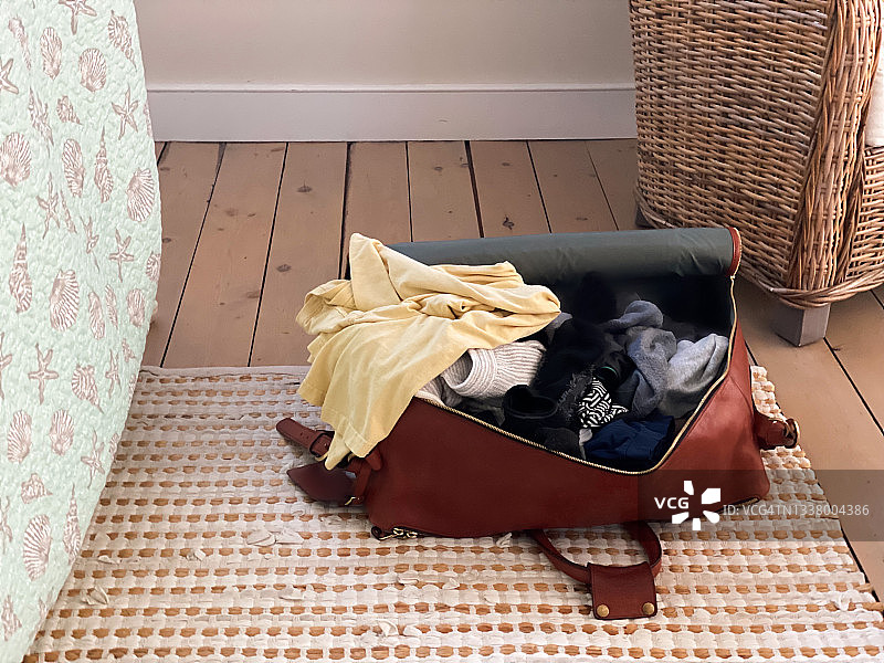海滨别墅卧室地板上的打开的行李箱图片素材