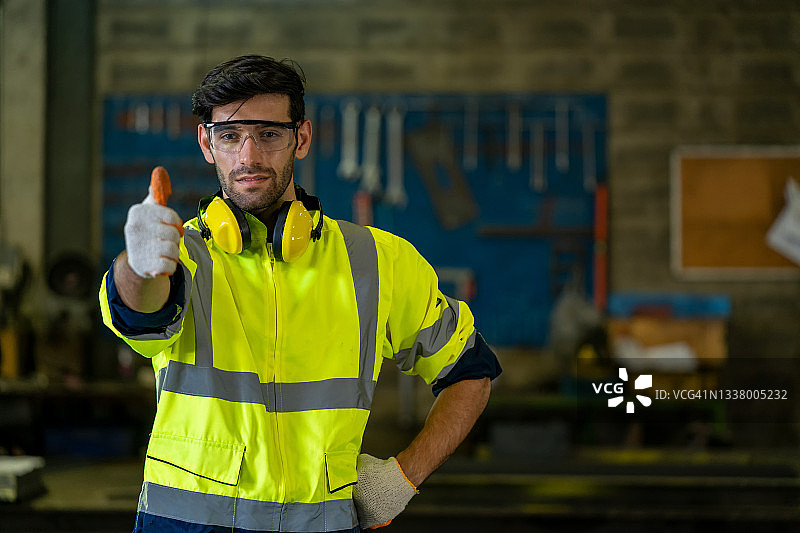 身穿安全制服站在工厂里的产业工人图片素材
