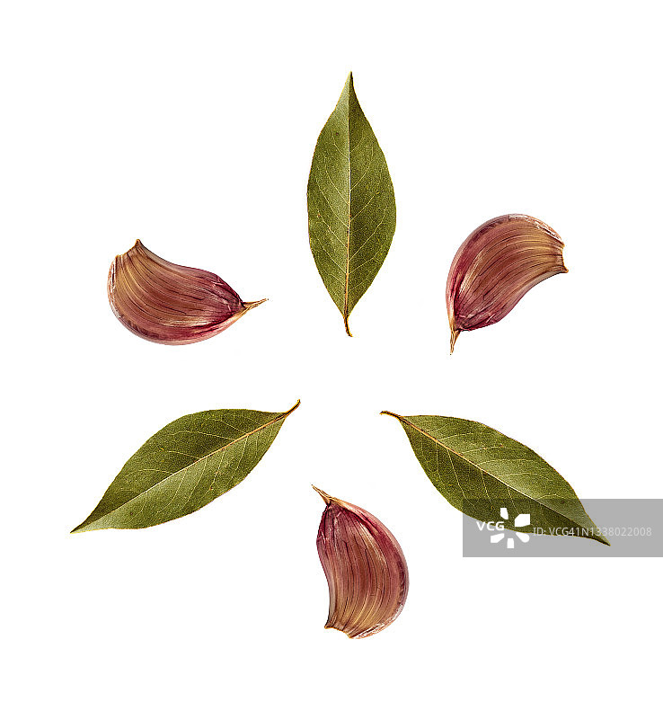 大蒜和月桂叶在白色背景上形成一个圆圈的特写图片素材