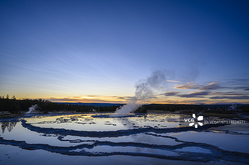 日落时分的大喷泉间歇泉；美国怀俄明州黄石国家公园火坑湖车道图片素材