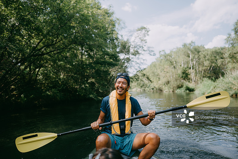 在日本北海道的河流上划皮划艇的快乐男人图片素材